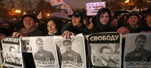 Demonstrators hold posters with portraits of jailed opposition activists Vladimir Akimenkov and Leonid Razvozzhayev and demanding their release, during a protest rally in Moscow, Russia, Tuesday, Oct. 30, 2012.